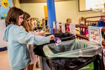 Students toss trash into designated garbage bins