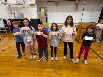 Smaller group of student raffle winners pose with their gift certificates