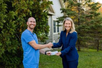 Dentist and community healthcare president pose with check