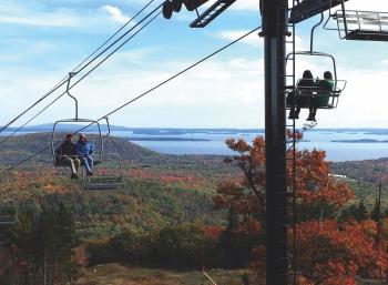 Riding the chairlift at the Camden Snow Bow up Ragged Mountain in Camden, with Penobscot Bay in the background. (Photo courtesy Camden Snow Bowl)