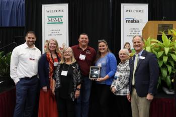 Chris and Tracey Leavitt, center, stand with a group of people after receiving their award. (Photo courtesy Krystle Weaver)