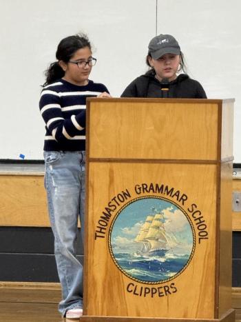 Two girls stand at a lectern