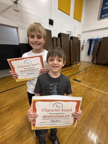 Two boys hold certificates