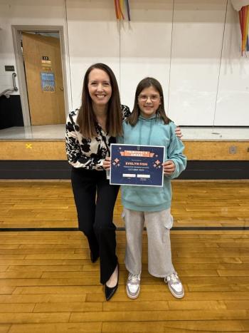 Adult and child pose with certificate