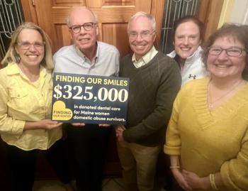 five adults and holding a sign