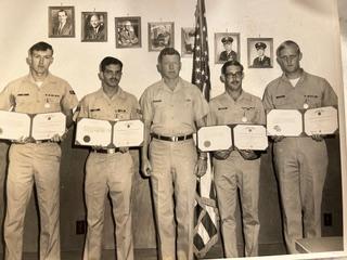 Group photo of five soldiers and their certificates