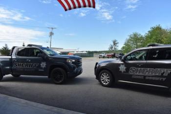 KCSO truck and SUV under American flag