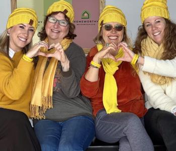 Four women combine hands for heart gestures
