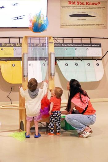 Mom and toddlers at an exhibit