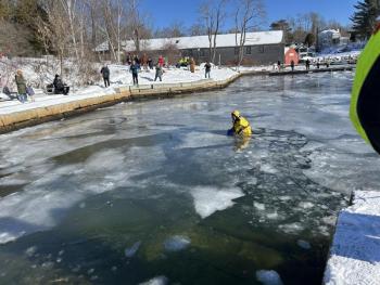 Camden Firefighter Derek Jay, in a cold water rescue suit, positions in the water for precautions. (Photo by Lynda Clancy)