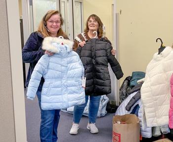Two women pose with winter coats