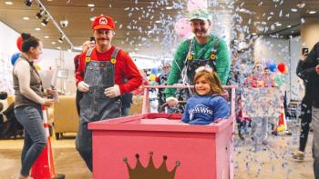 Adults in Nintendo costumes, girl in pink cart
