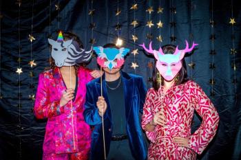 three people holding face masks pose for the camera