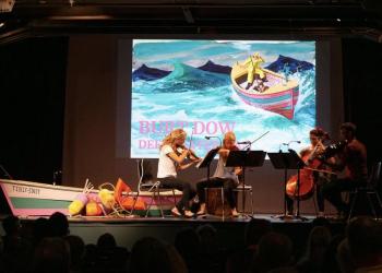 stage scene of musicians and slide show