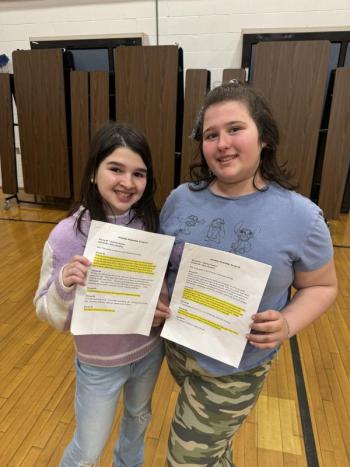 Two girls hold their scripts