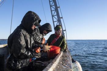 three people on bow of vessel
