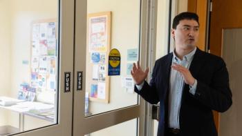 Zach Schwartz stands by doors at the entrance of a building