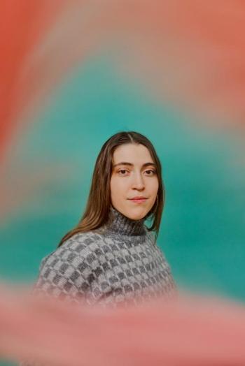 woman in portrait framed by pink cloud