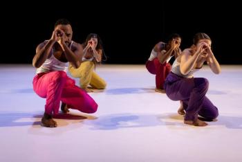 four dancers at a crouch