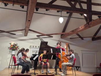 five teenagers play instruments