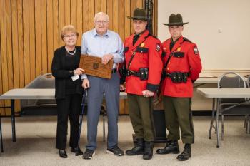 Four adults pose with award plaque