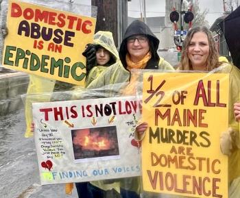 three women protesting in the rain