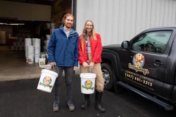 man, woman pose with buckets