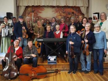 band members pose with instruments on small stage