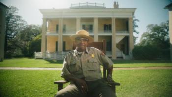 man in uniform in front of house