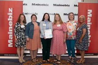 Six women pose in front of MaineBiz backdrop