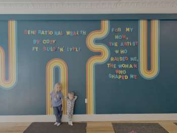 children lean against a decorated wall