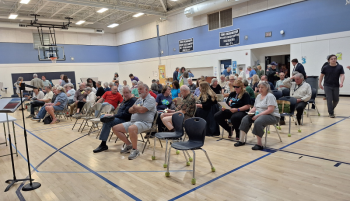 People filter into the auditorium, slowly filling seats. (photo by Erica Thoms)