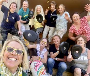 group selfie of women wearing punching mitts