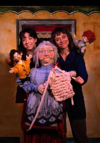 two women pose with puppets