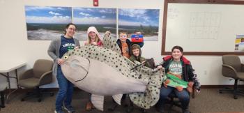 woman, children with big fake fish
