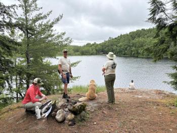 people, dog at water's edge