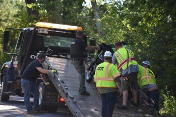 group loads bike onto wrecker
