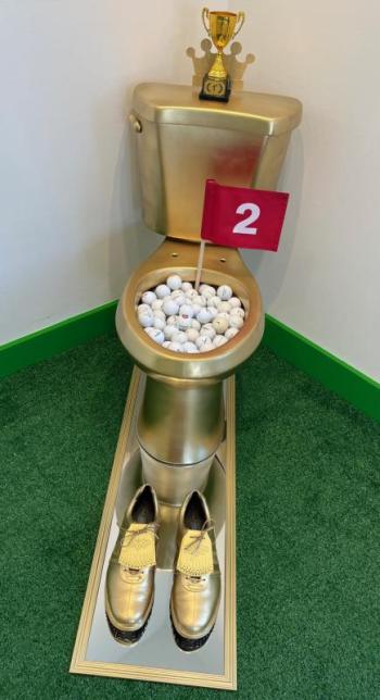 golden toilet with golf equipment