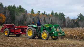 green tractor pulling red trailer