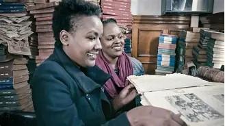 two women among piles of books