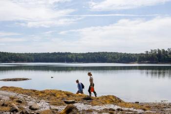 two women walking as they survey for oysters