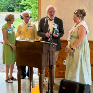 three people stand with award winner