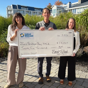 three people pose with presentation check