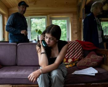 young woman talking on a landline phone.