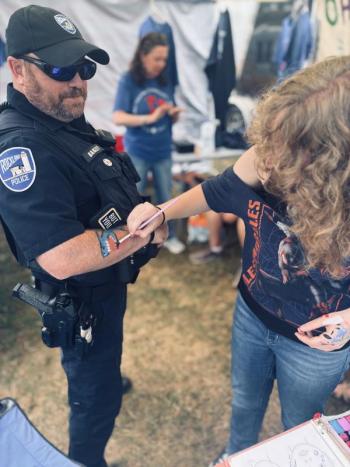 student paints picture on police office arm