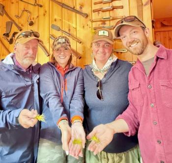 four people holding fishing lures