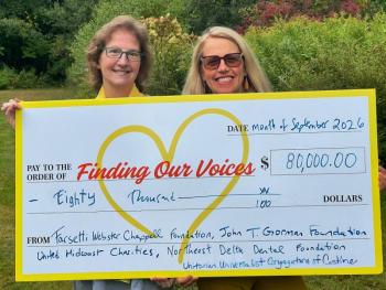 two women pose with presentation check