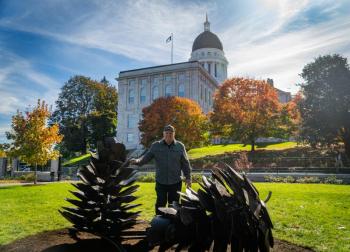 man, sculptures, capitol building in background