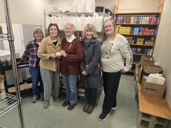 five women pose with check