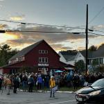 As the sun sets Oct. 1, a crowd gathers at Flatbread Pizza, in Rockport, to meet U.S. Senate hopeful Graham Platner. (Photo by Lynda Clancy)